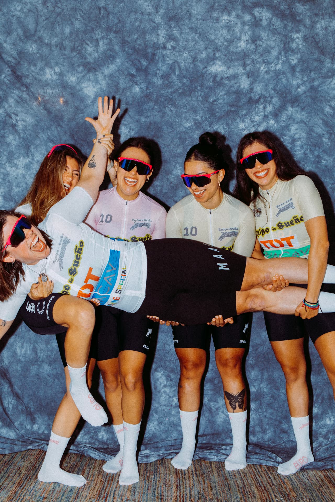 ELLAS riders carrying one teammate horizontally while laughing